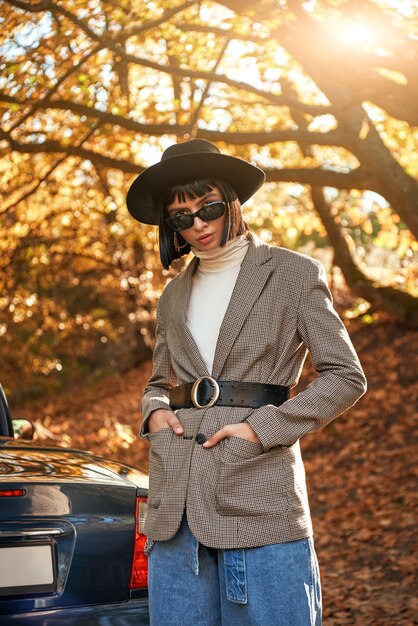 Hermosa mujer joven posando junto a la temporada de otoño descapotable