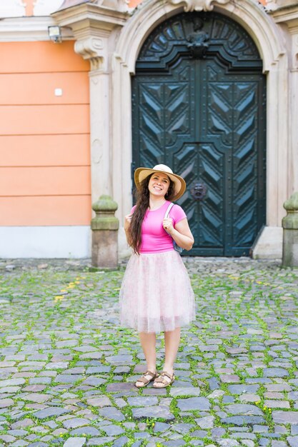 Foto hermosa mujer joven posando con el telón de fondo de una puerta vieja.