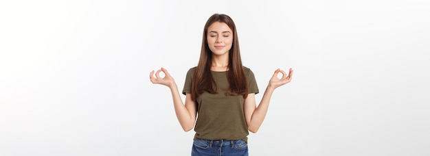 Hermosa mujer joven en posición de yoga y meditación aislada sobre fondo gris