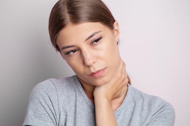 Hermosa mujer joven que sufre de dolor de cuello