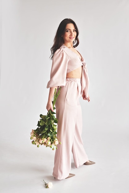 Hermosa mujer joven con ramo de flores de rosas Día Internacional de la Mujer