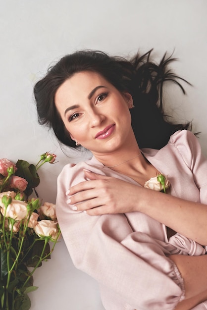 Hermosa mujer joven con ramo de flores de rosas Día Internacional de la Mujer