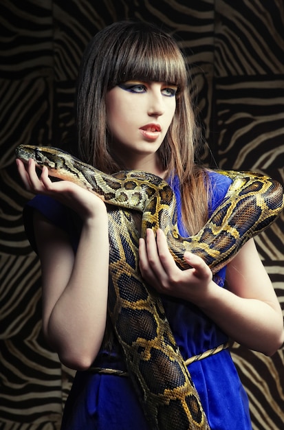 Hermosa mujer joven con una serpiente