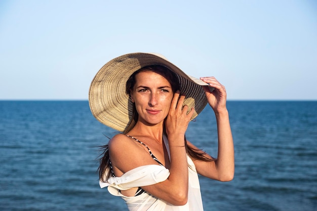 Hermosa mujer joven sexy en un sombrero en el fondo del mar