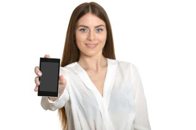 Hermosa mujer joven con smartphone aislado sobre fondo blanco.