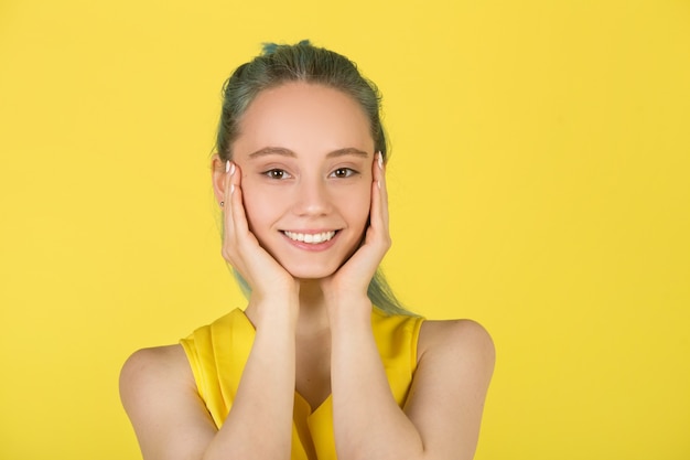 Hermosa mujer joven sobre un fondo amarillo