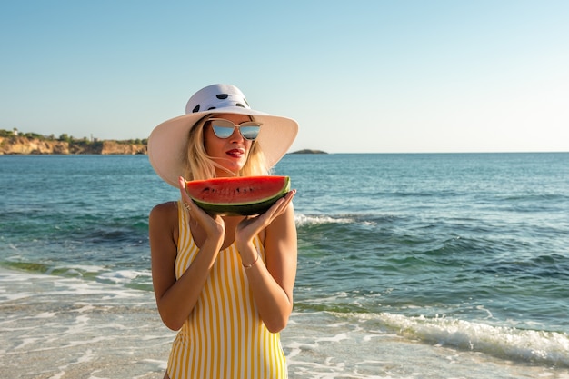 Hermosa mujer joven con un sombrero con sandía.