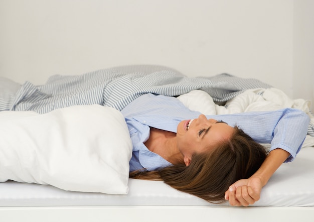 Foto hermosa mujer joven sonriendo en la cama