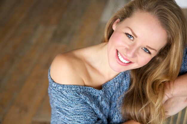 Hermosa mujer joven sonriendo en casa