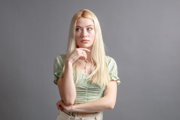 Hermosa mujer joven sonriente con el concepto de belleza natural de la cara de la piel perfecta aislada en el fondo gris del estudio