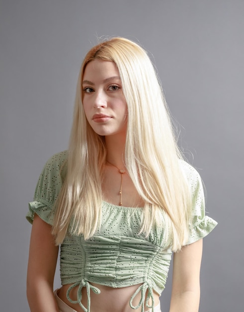 Hermosa mujer joven sonriente con el concepto de belleza natural de la cara de la piel perfecta aislada en el fondo gris del estudio