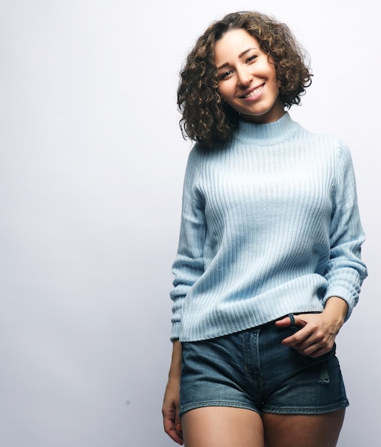 Hermosa mujer joven sonriente sobre fondo gris