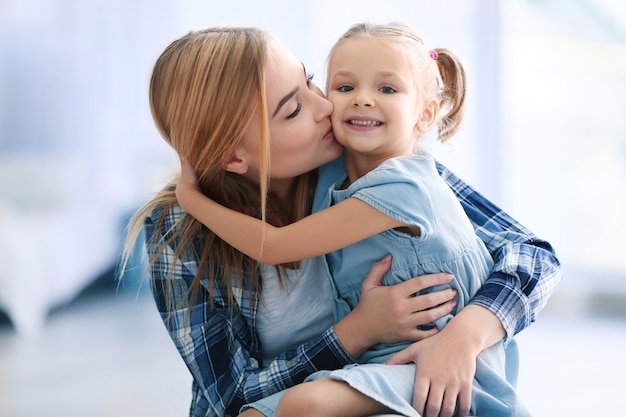 Hermosa mujer joven y su hija en casa.