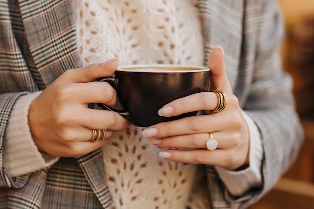 Hermosa mujer joven en suéter caliente tomando café. Mañana de otoño.