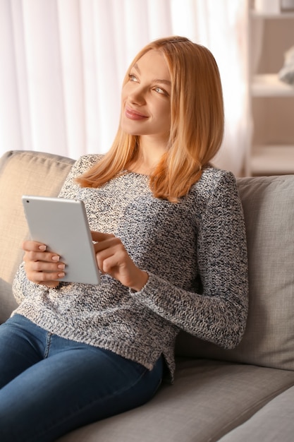 Hermosa mujer joven con tablet PC en casa