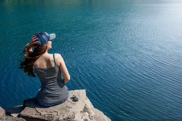 Hermosa mujer joven en traje de baño de pie en el lago por la mañana. Concepto de turismo. Concepto de verano