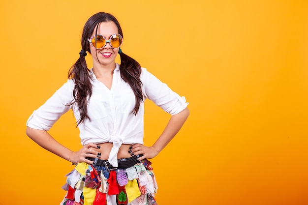 Hermosa mujer joven con traje funky sobre fondo amarillo. Humor tonto