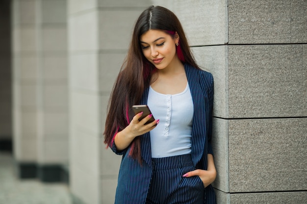 hermosa mujer joven en traje con teléfono móvil