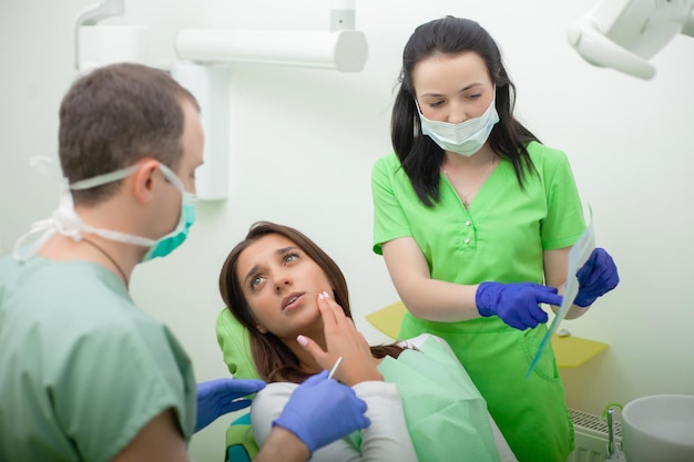 Hermosa mujer joven con tratamiento dental en el dentista