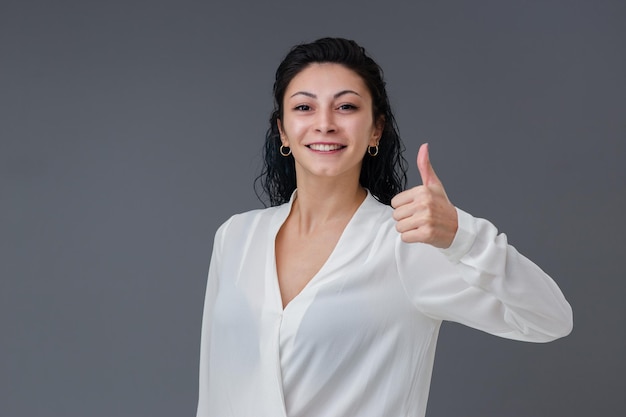 Hermosa mujer joven turca sonriente gestos concepto ella pulgares hacia arriba incluye espacio de copia