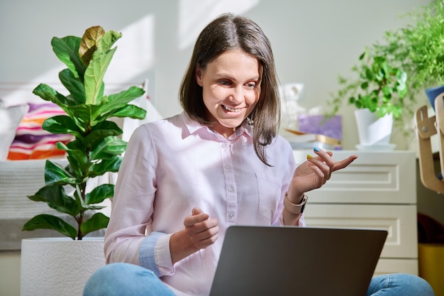 Hermosa mujer joven usando una computadora portátil para chat de video