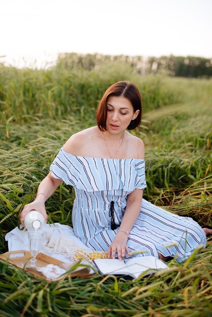 Hermosa mujer joven en verano en un campo de trigo