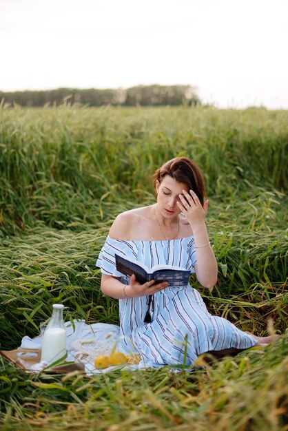 Hermosa mujer joven en verano en un campo de trigo