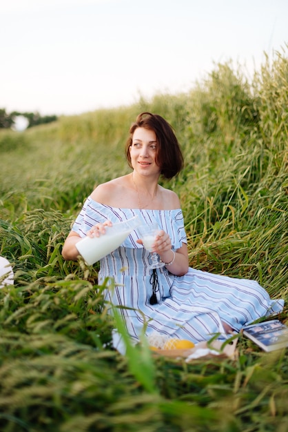 Hermosa mujer joven en verano en un campo de trigo