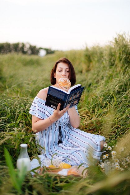 Hermosa mujer joven en verano en un campo de trigo