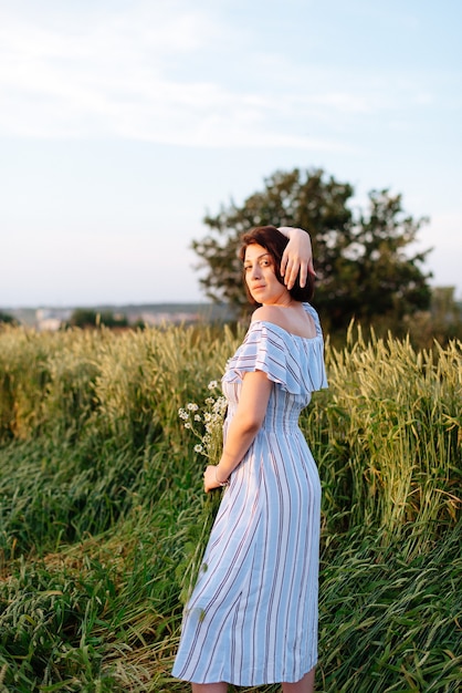 Hermosa mujer joven en verano en un campo de trigo