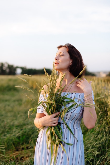 Hermosa mujer joven en verano en un campo de trigo