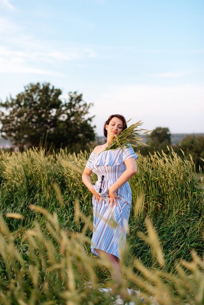 Hermosa mujer joven en verano en un campo de trigo