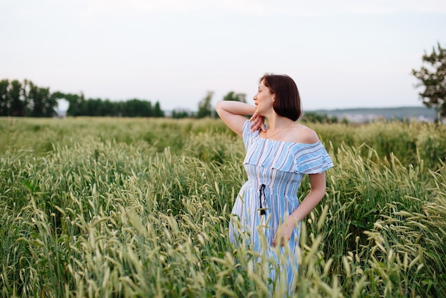 Hermosa mujer joven en verano en un campo de trigo