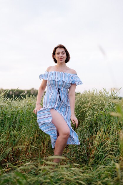 Hermosa mujer joven en verano en un campo de trigo