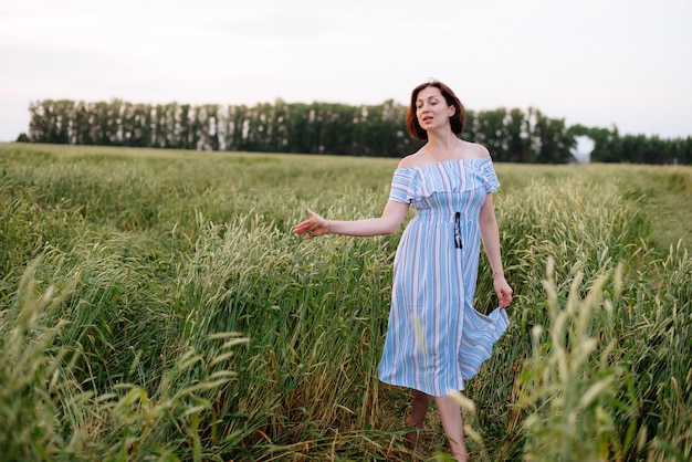 Hermosa mujer joven en verano en un campo de trigo