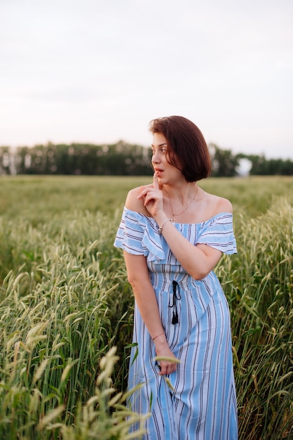 Hermosa mujer joven en verano en un campo de trigo