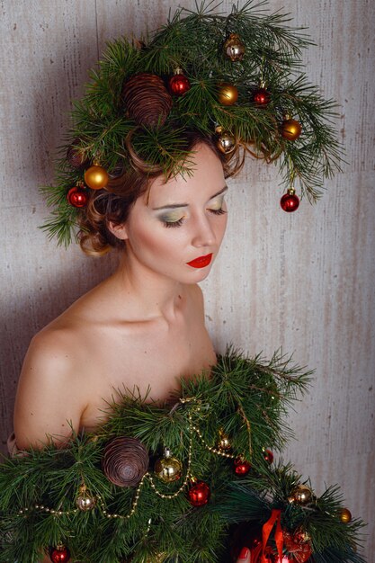 Hermosa mujer joven con un vestido de árbol de Navidad