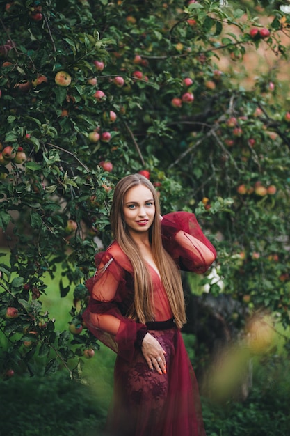 Una hermosa mujer joven con un vestido de bardo contempla el campo y el jardín.