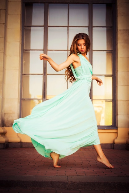 Hermosa mujer joven en un vestido elegante de menta