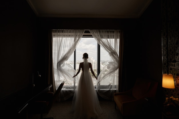 Hermosa mujer joven en un vestido de novia, retrocediendo