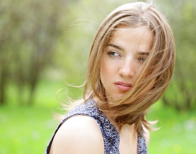 Hermosa mujer joven en vestido romántico relajante en el jardín