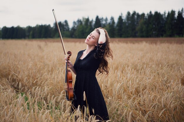 Hermosa mujer joven con un violín