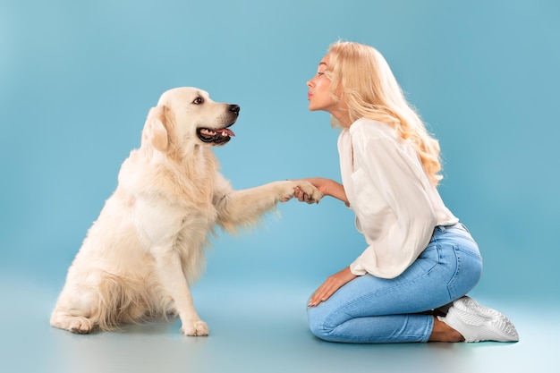 Hermosa mujer jugando con perro en el estudio