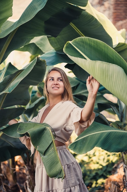 Hermosa mujer en la jungla Un resort u hotel con árboles y plantas tropicales Mujer con hoja de plátano cerca Chica de vacaciones en la selva tropical