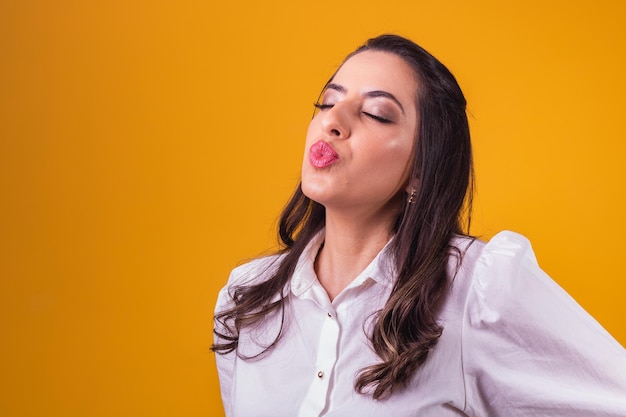 Hermosa mujer con labios fruncidos que sopla beso con espacio para texto.