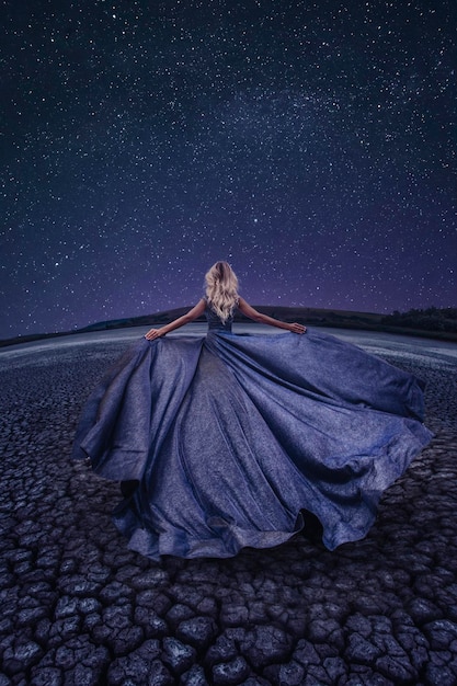 Hermosa mujer en lago seco en la noche