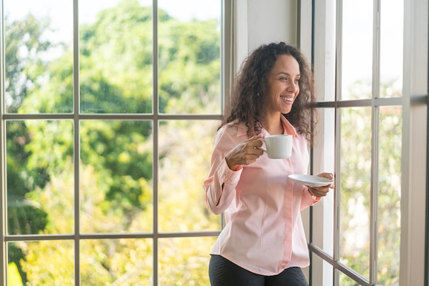 hermosa mujer latina tomando café por la mañana