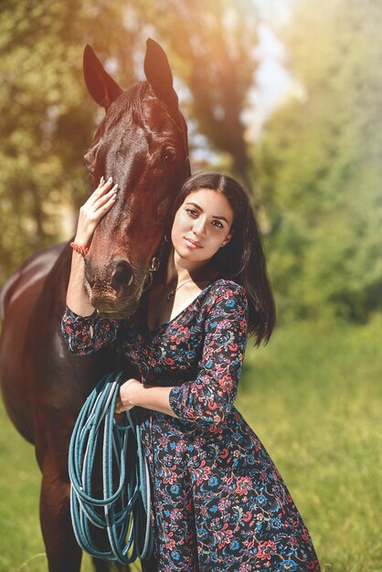 Foto hermosa mujer latina vestida y su hermoso paseo a caballo en el bosque. amor concepto de animales. amo los caballos