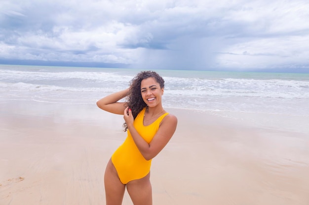 Hermosa mujer latinoamericana en bikini en la playa Mujer joven disfrutando de sus vacaciones de verano en un día soleado sonriendo y mirando a la cámara