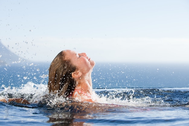 Hermosa mujer levantando la cabeza fuera del agua